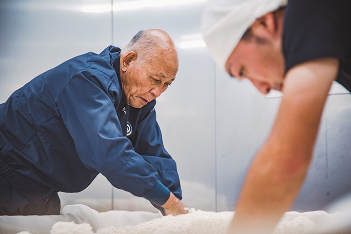 在麴室工作。 “麴釀造是清酒釀造的核心，”野口先生嚴厲的表情說