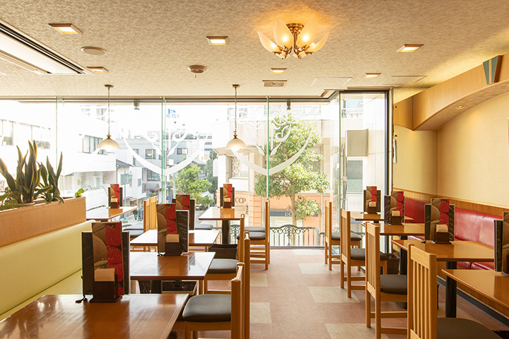 窗戶很大，而且是敞開的。 牆邊還有帶沙發的桌子座位。