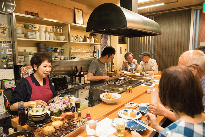 在吧台座位上，熟悉的客人在聊天，氣氛很舒適。