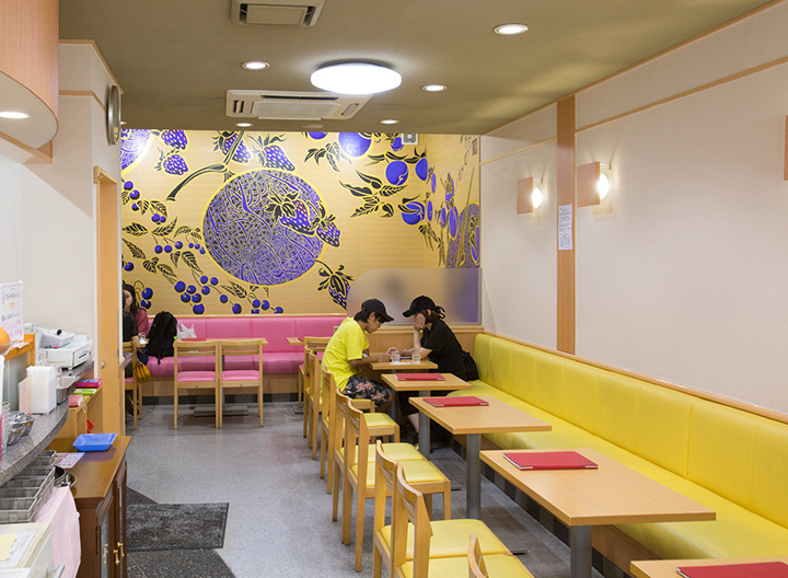 店內以黃色為主調，牆上掛著水果的畫作。