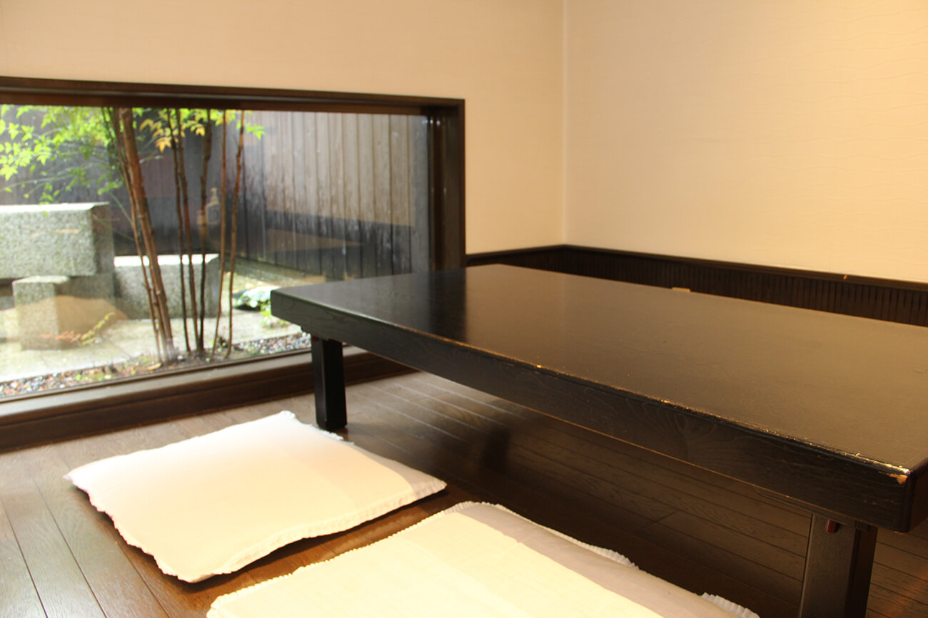 在燈光平靜的榻榻米房間裡，有三張四人桌