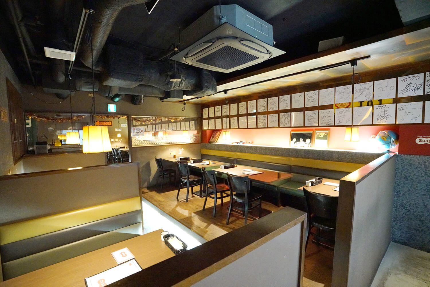 店內寬敞，氛圍輕鬆。 牆上裝飾著許多名人的簽名