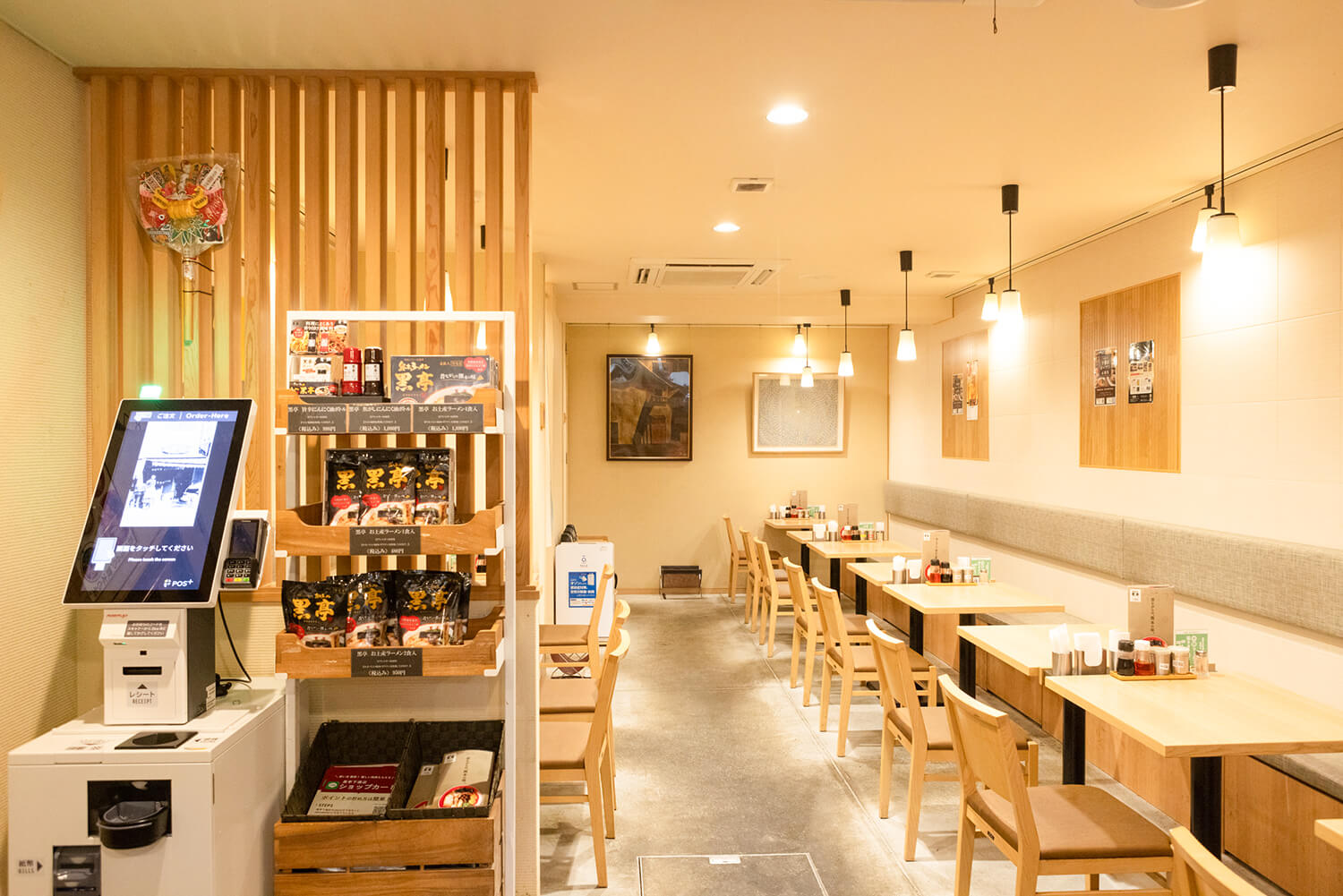 內部明亮簡約，白色配色。 進店後，在食券機上購買食券。