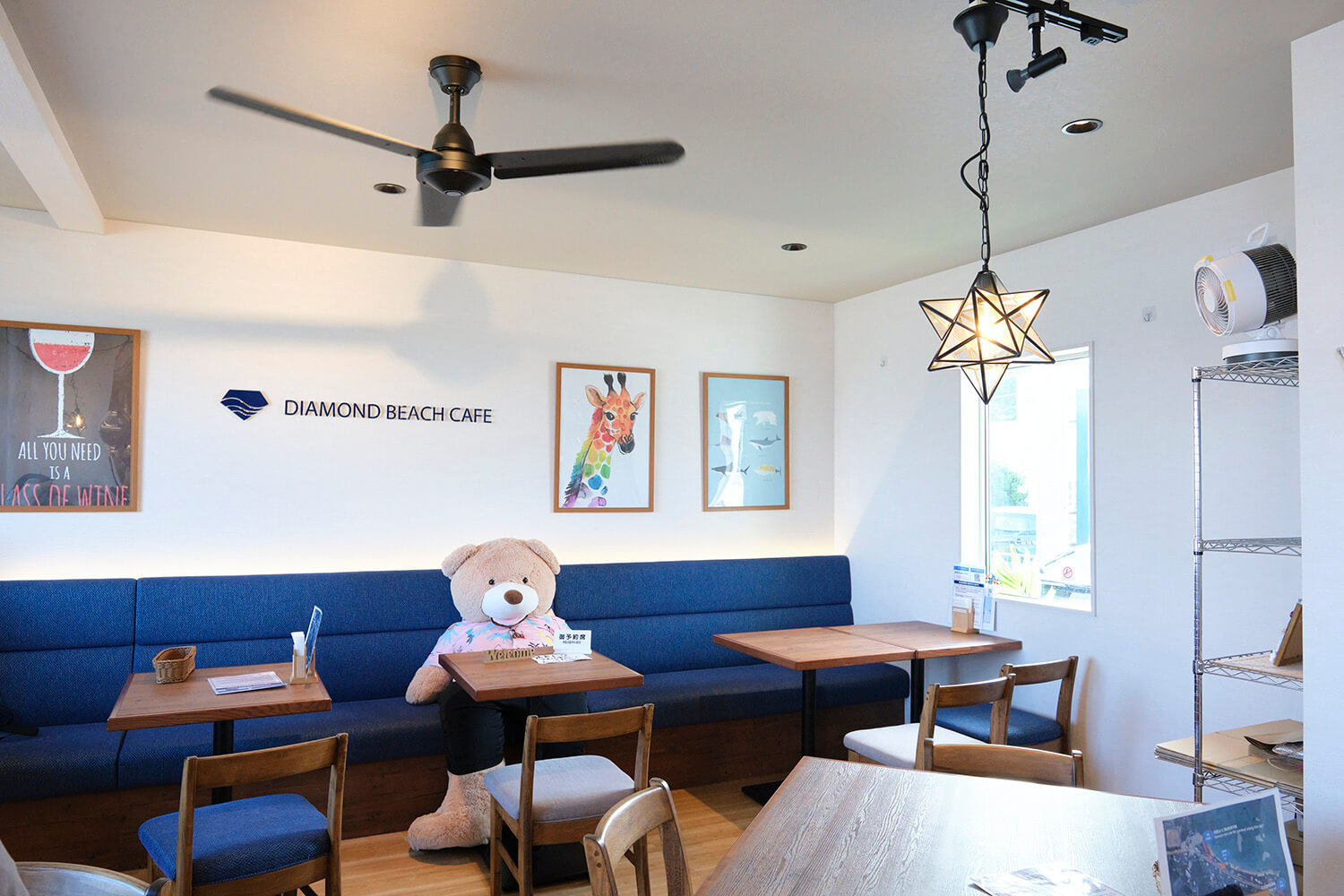 店裡沙發座位上坐著的大泰迪熊是他的商標