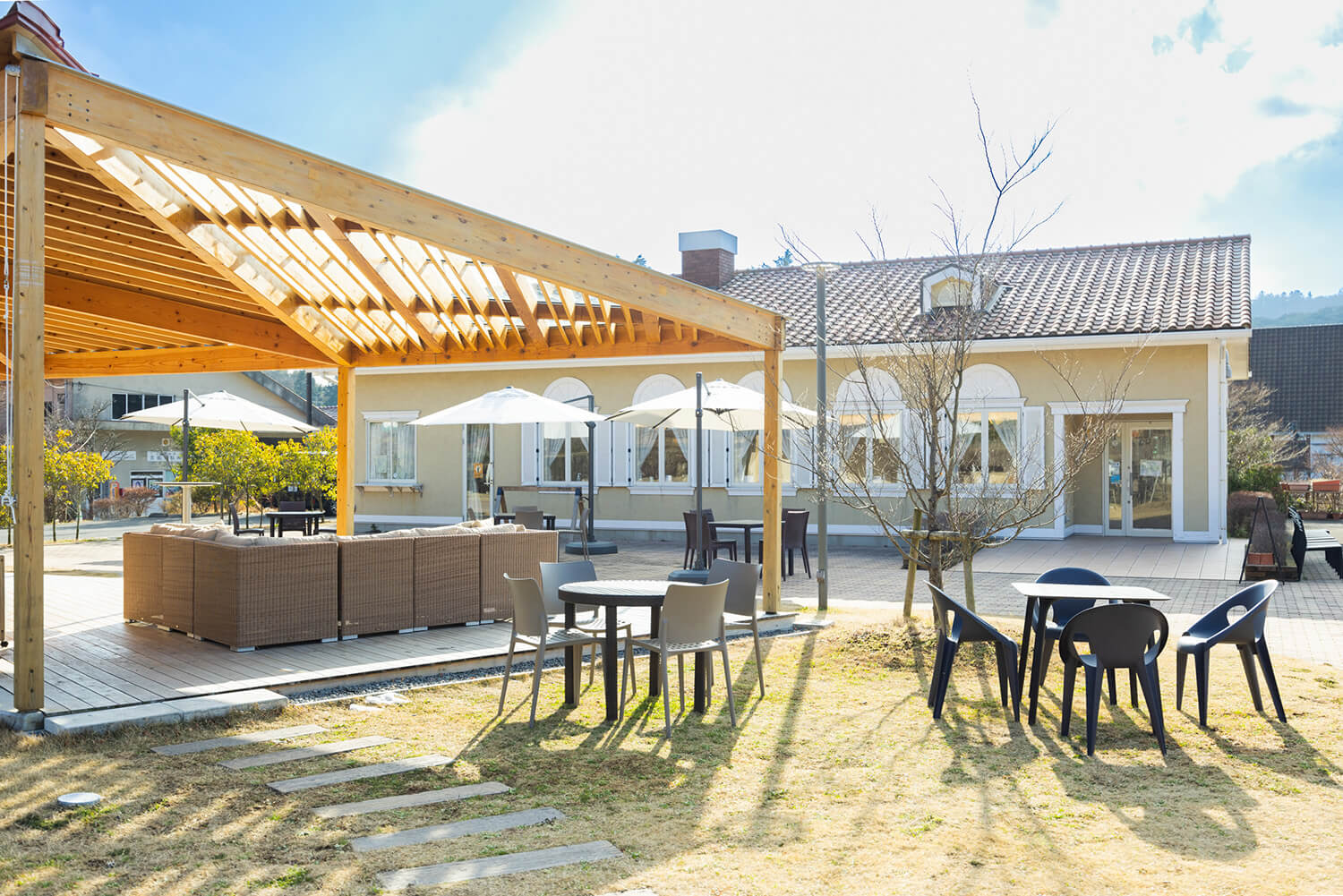 正面是「綠露臺雲仙」。 前景是「Marco's Cafe」的露臺座位，你可以在這裡和你的狗狗共度時光。 院內亦設有足浴