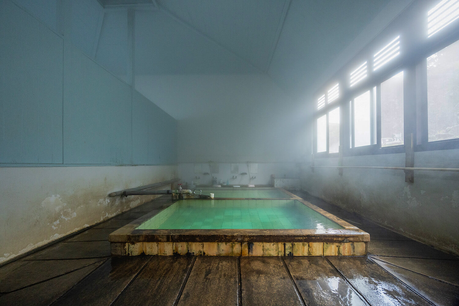 浴缸底部的翠綠色瓷磚在朝陽的映照下格外美麗