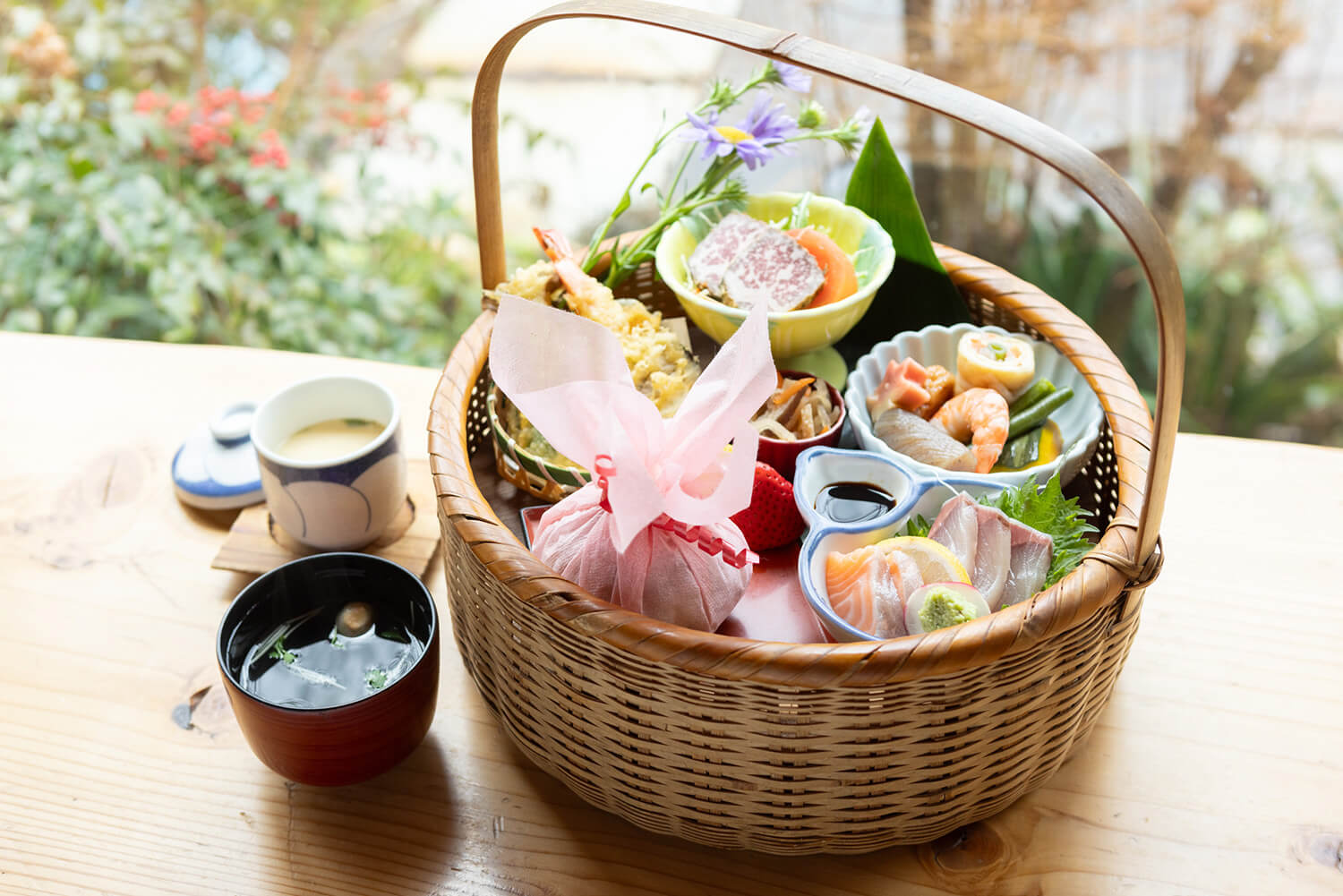 「花籃便當」JPY2200。 飯糰用桃色的和紙包著。 小菜的種類很多，而且比看起來更豐盛。