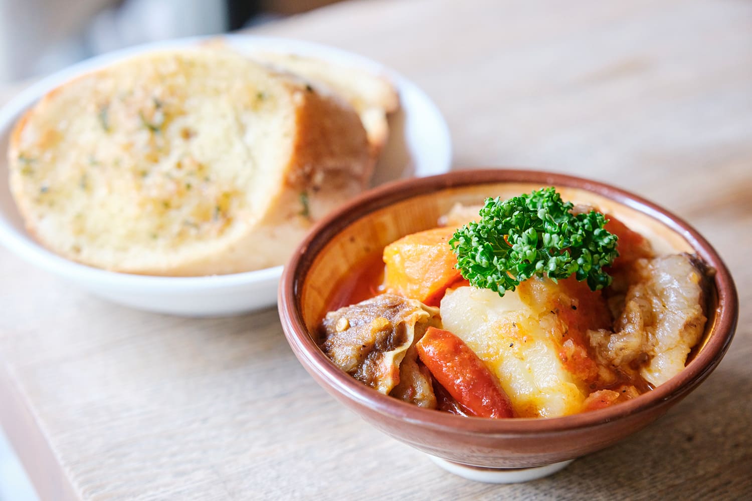 右起：「牛筋番茄燉菜」473日圓、「蒜味吐司（2個）」220日圓