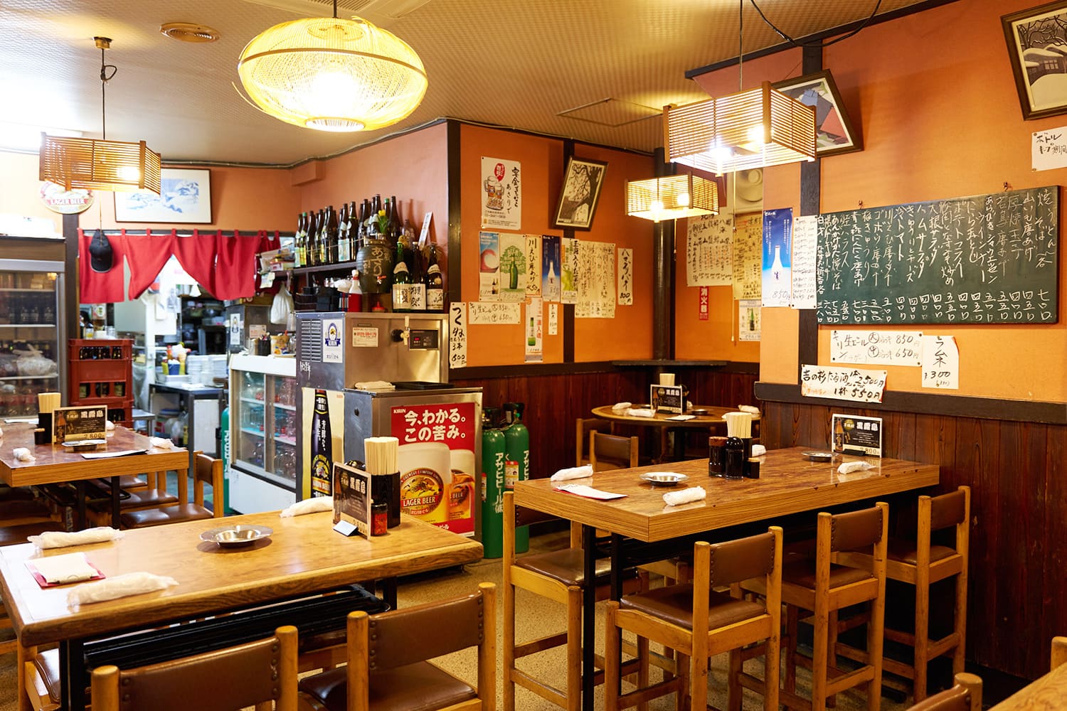 菜單排列在店的牆上。 古色古香的居酒屋裡擠滿了客人，氛圍很舒適