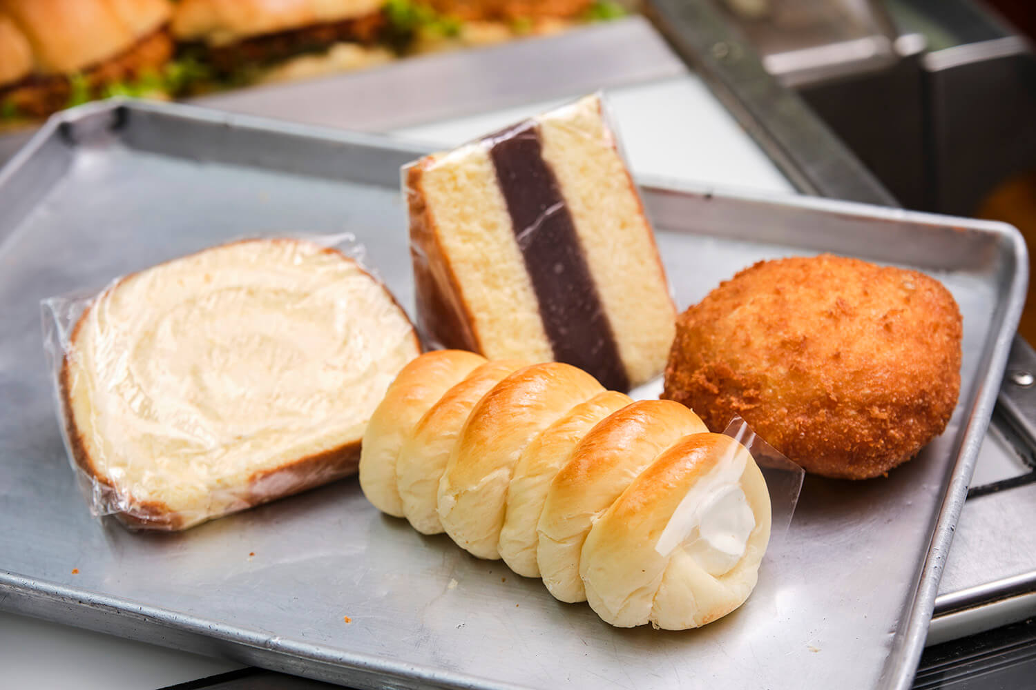 從中央正面順時針方向，「鮮奶油科羅內」292日圓、「卷蛋糕」378日圓、「西伯利亞麵包」367日圓、「牛肉咖哩麵包」292日圓