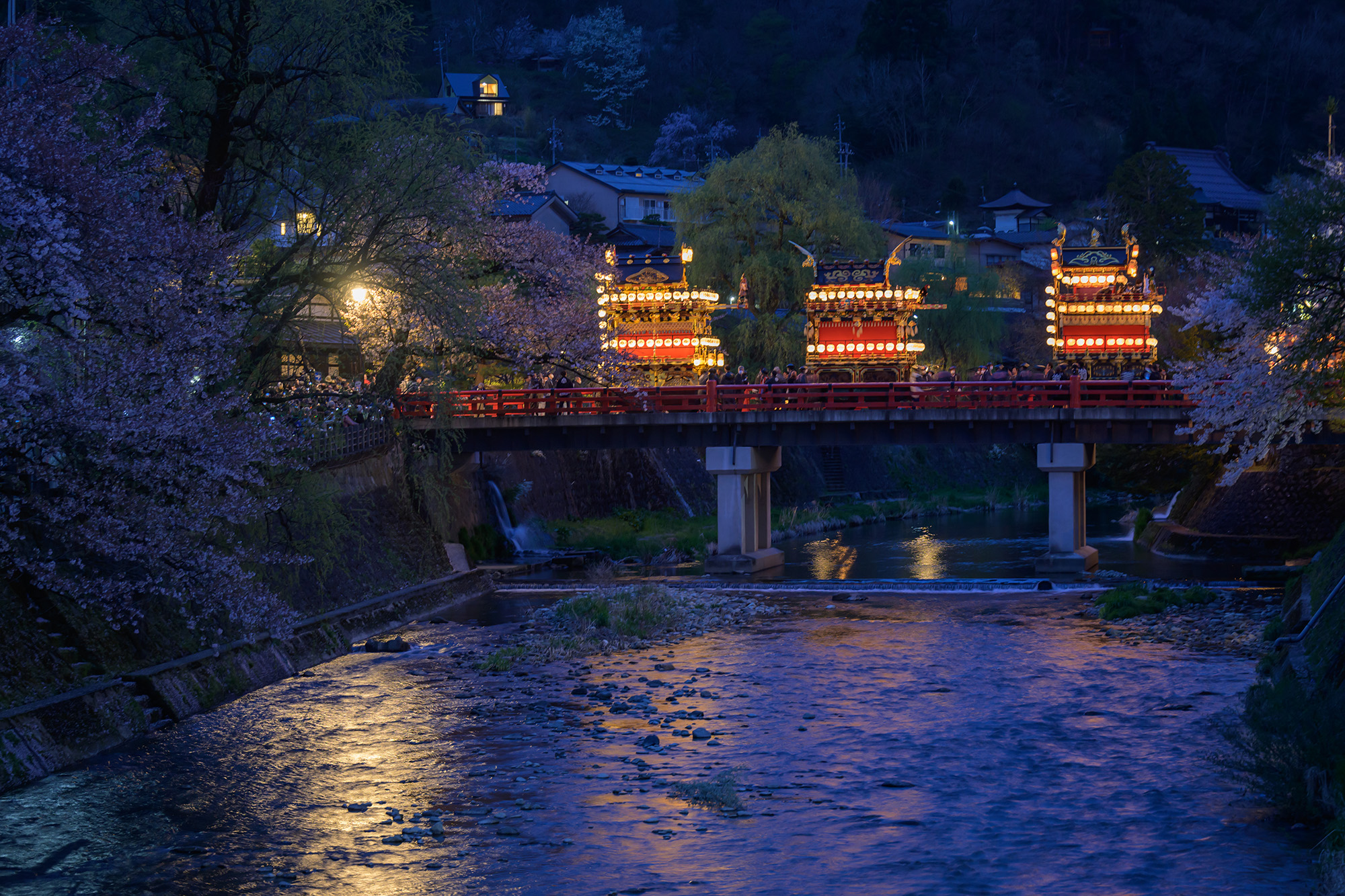 中橋對面擺放著燈籠的攤位，宛如夢幻般的夜祭場景