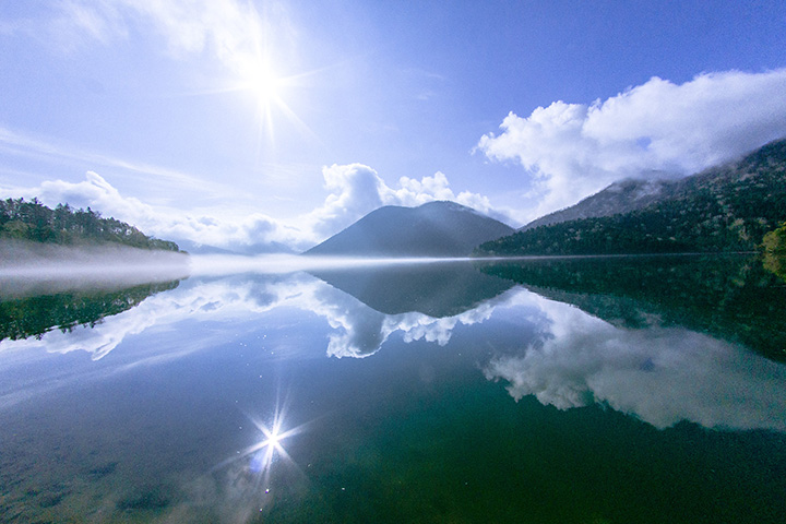 鏡のように景色を映し出す然別湖。正面にはくちびる山