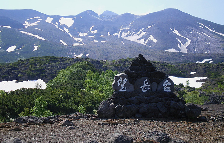 登山道の入り口にある望岳台の積み石と十勝岳