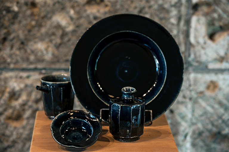 瑠璃釉を使った黒に近いネイビーがモダンな表情の器。阿久津忠男作。小皿1,000円、中皿3,800円（全て税別）など