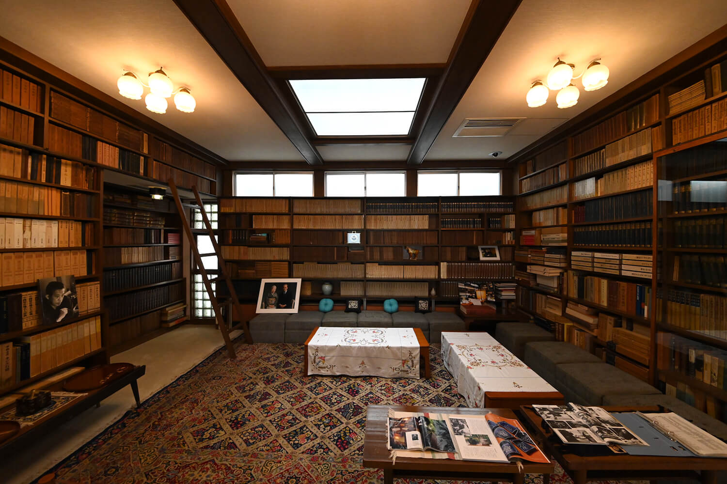天井まである書棚に並ぶ文献や書籍に囲まれた応接間