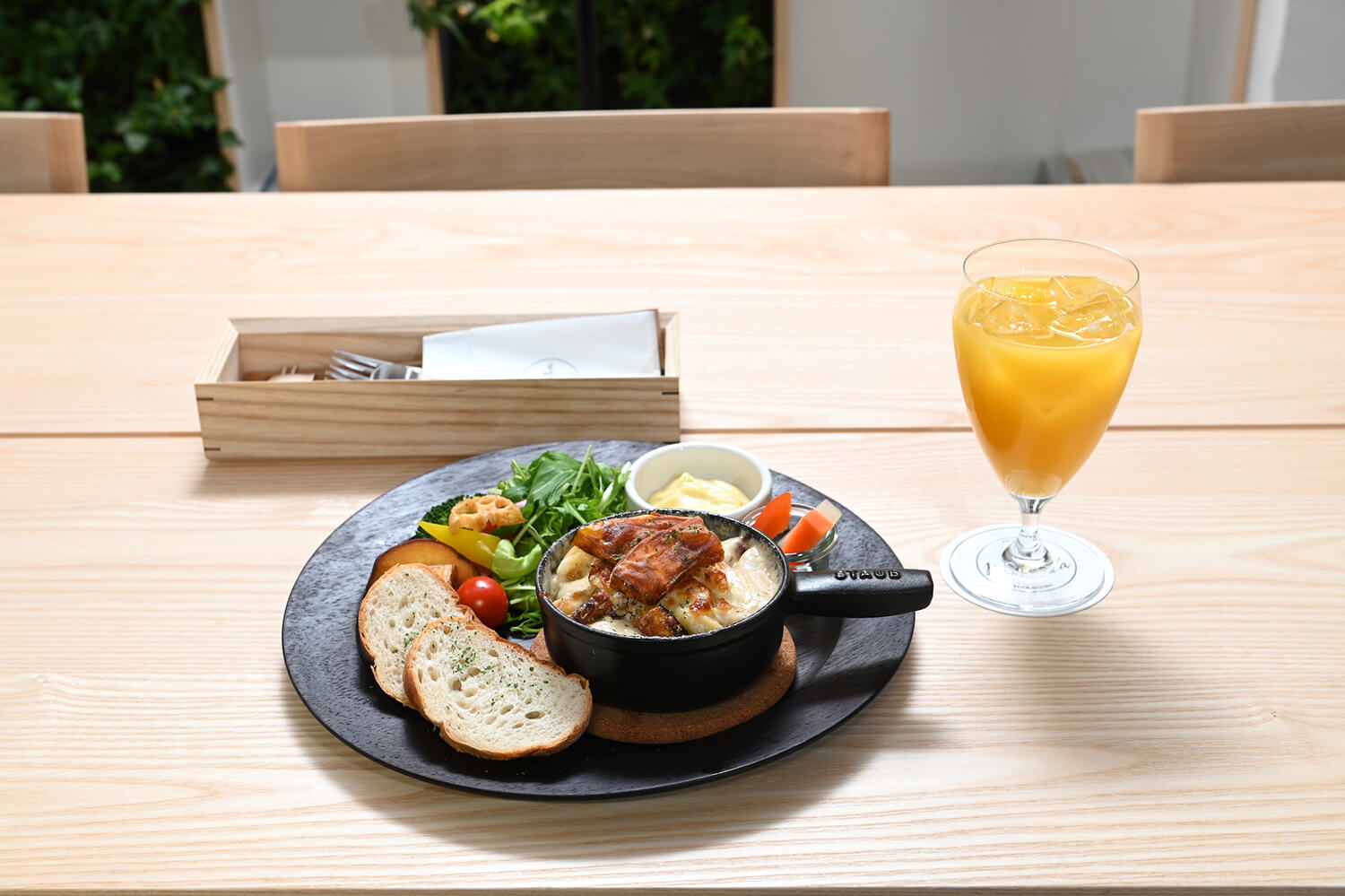 料理の味を引き立てる北海道産の野菜が添えられた「野菜たっぷりサラダプレート」（スープ・ライスorバケット付）1250円とオレンジジュース450円
