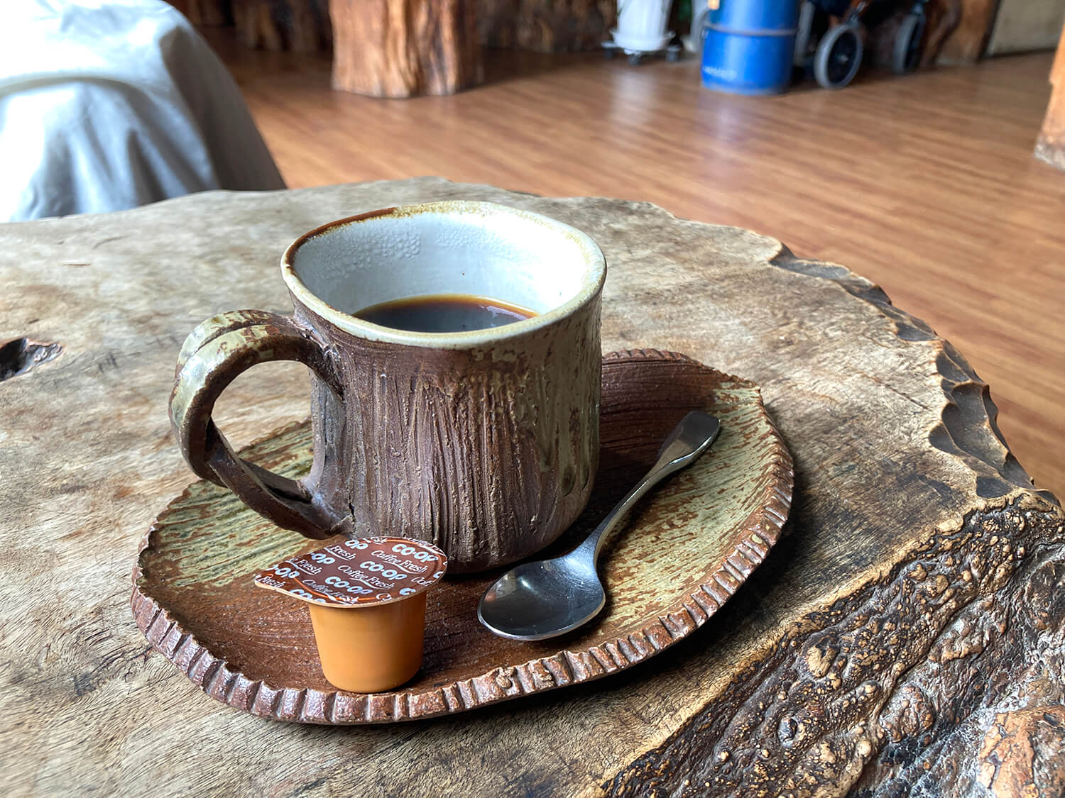 「オリジナルブレンドコーヒー」600円。重厚な一枚板のテーブルに木を模した器がしっくりとなじむ