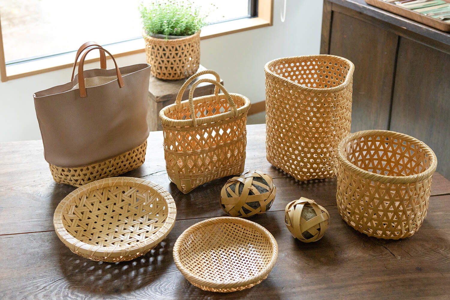 手に取るとよく分かる網目の美しさ。竹細工とレザーを組み合わせた籠やバッグもあり、竹細工の新たな魅力を提案している