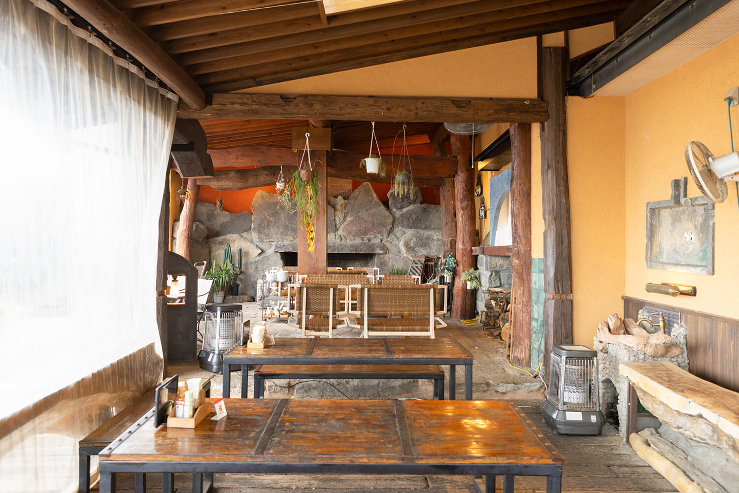 タイのチェンマイから買い付けた重厚感のあるテーブルやイスなどが配された店内。屋外にはウッドデッキの席もある