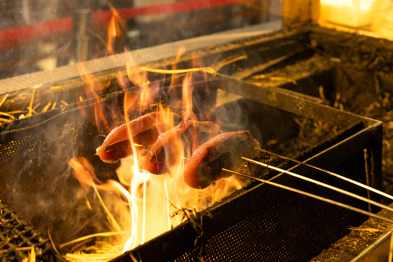 豪快に焼き上げる藁焼きのパフォーマンス。この火力で炙ることで旨みをギュッと閉じ込める