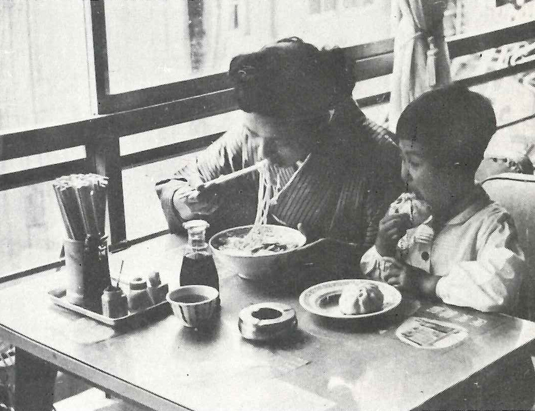 蓬莱食堂で食事をする親子。子どもは豚まんを頬張っている