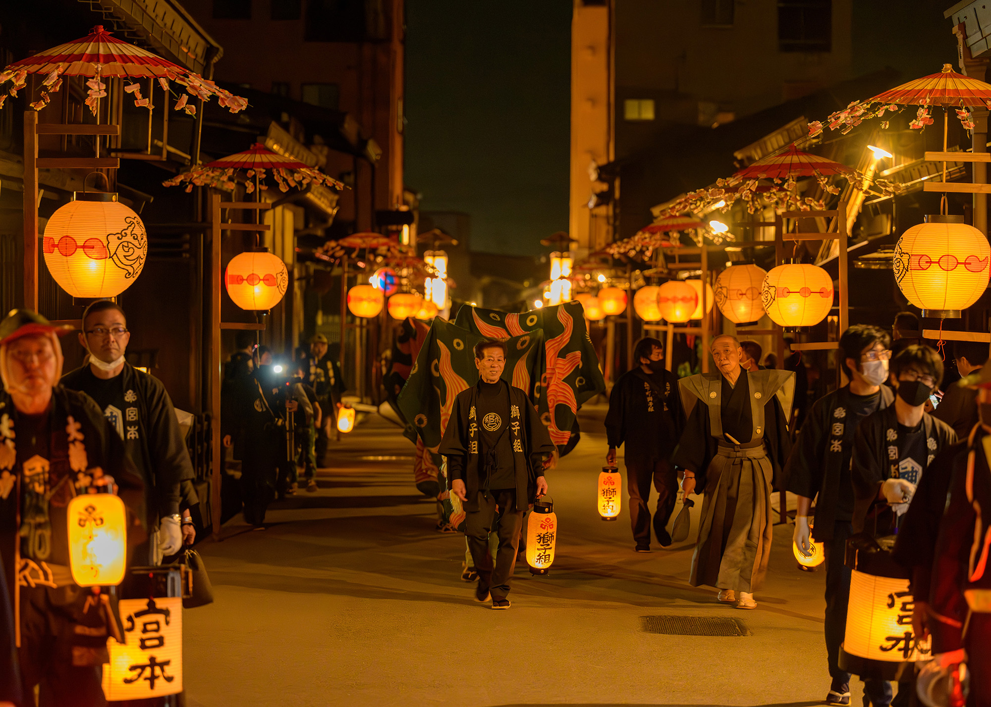 家々の前に飾られた提灯が夜の町並みを照らす