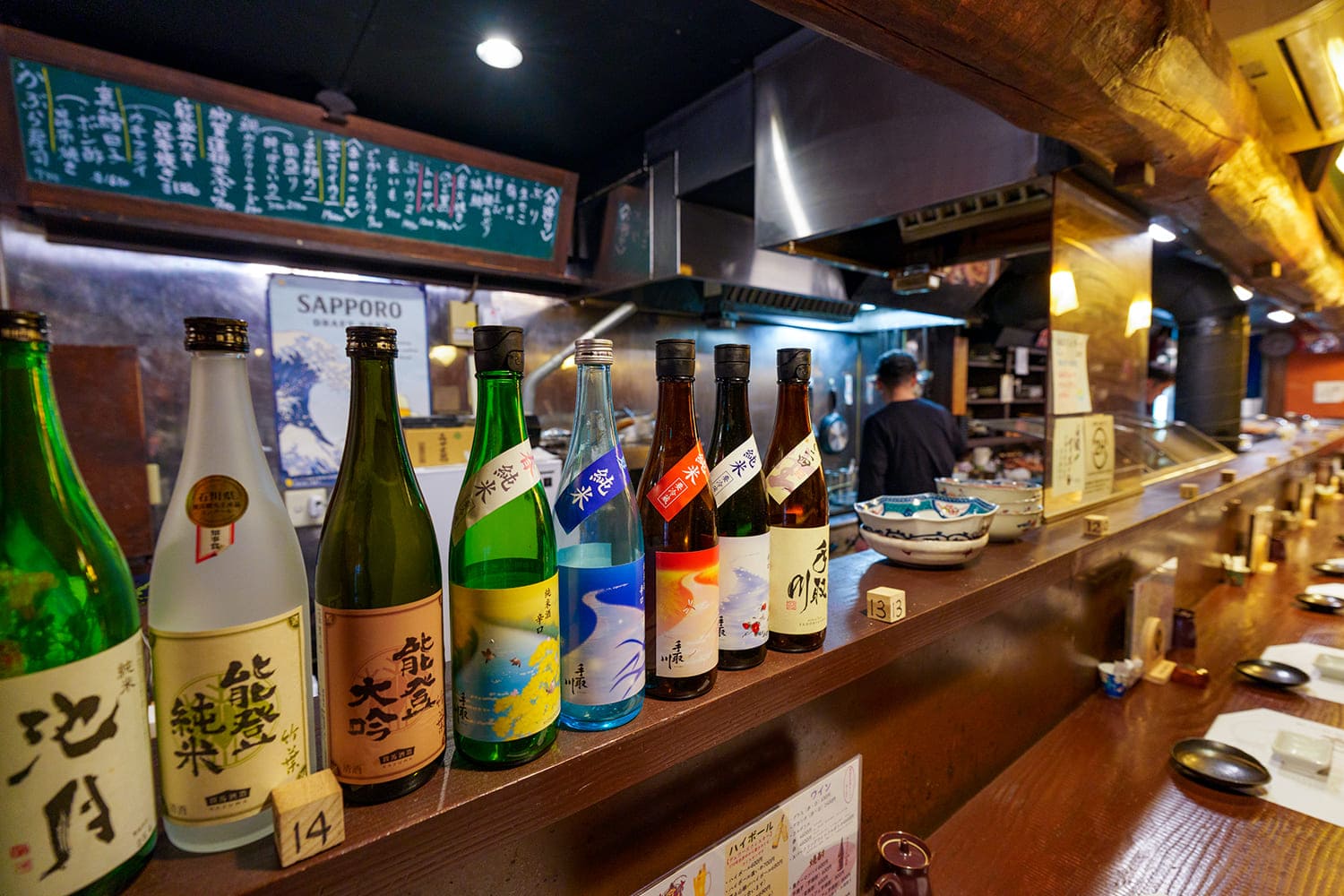 カウンターにずらっと並ぶ一升瓶の数から、並々ならぬ日本酒へのこだわりを感じる