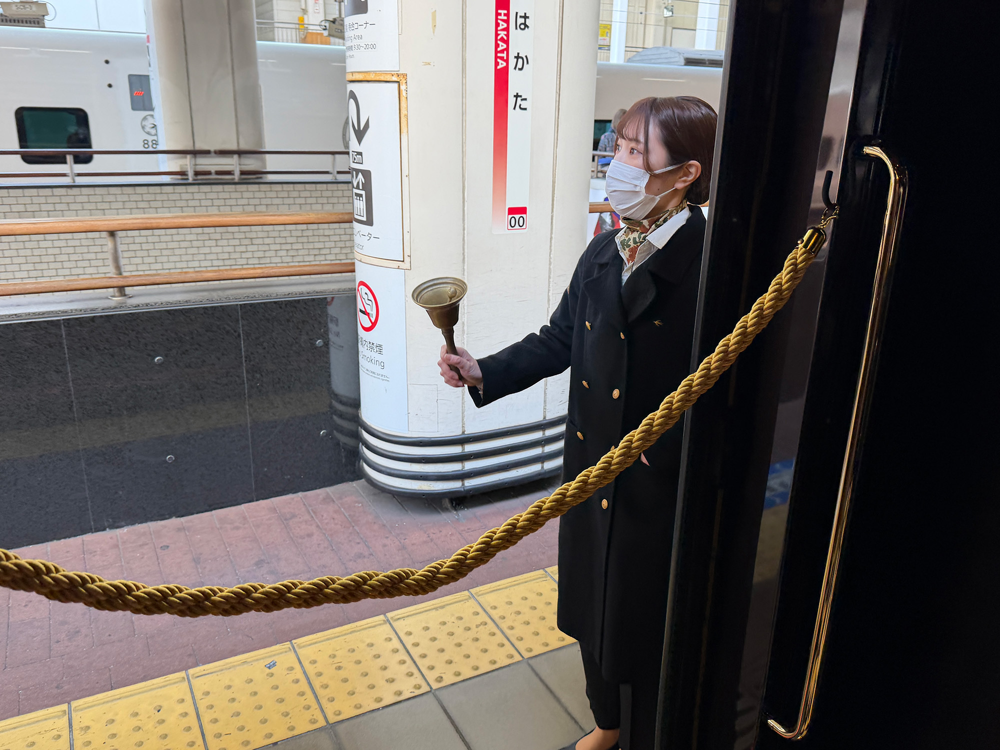 ベルを鳴らして発車を知らせるクルー