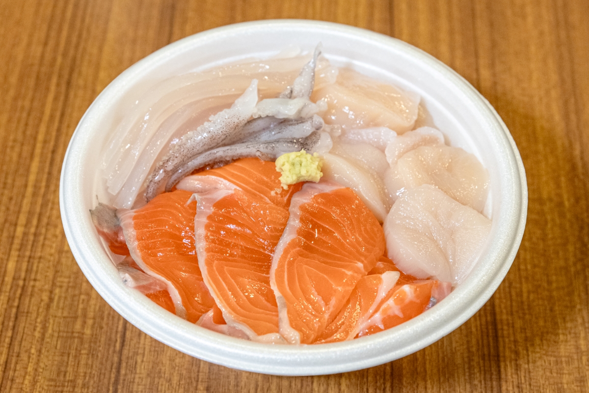 「中村鮮魚店」のサーモン、「富田鮮魚店」の活イカ、「前鮮魚店」のホタテ、そしてご飯を買って組み合わせた海鮮丼の一例